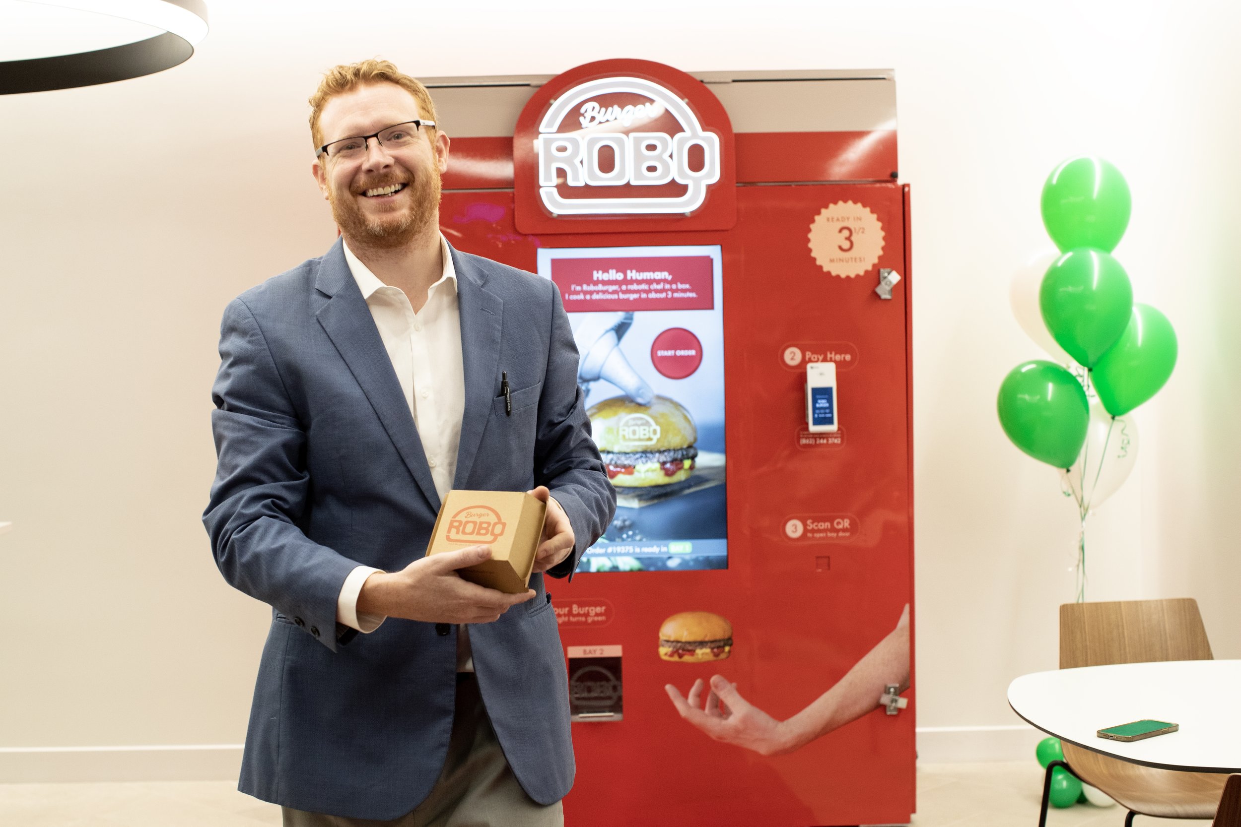 RoboBurger autonomous robot kitchen illuminated in neon lighting